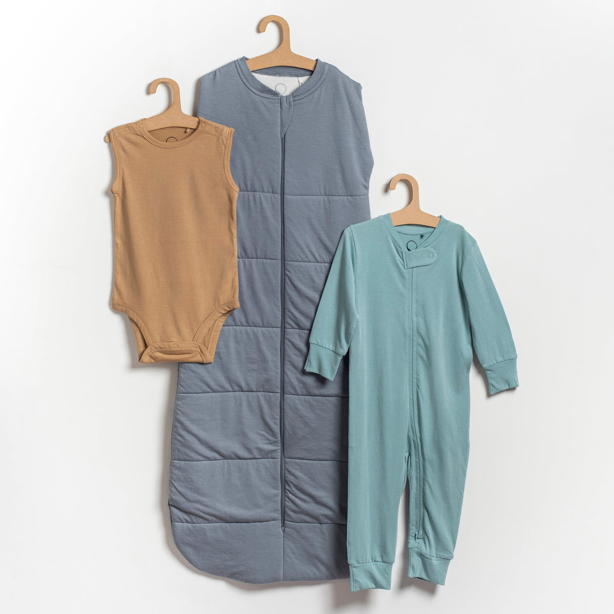 Three EverNest essentials arranged as a bundle: sleeveless singlet, full sleeve romper, and sleep sack